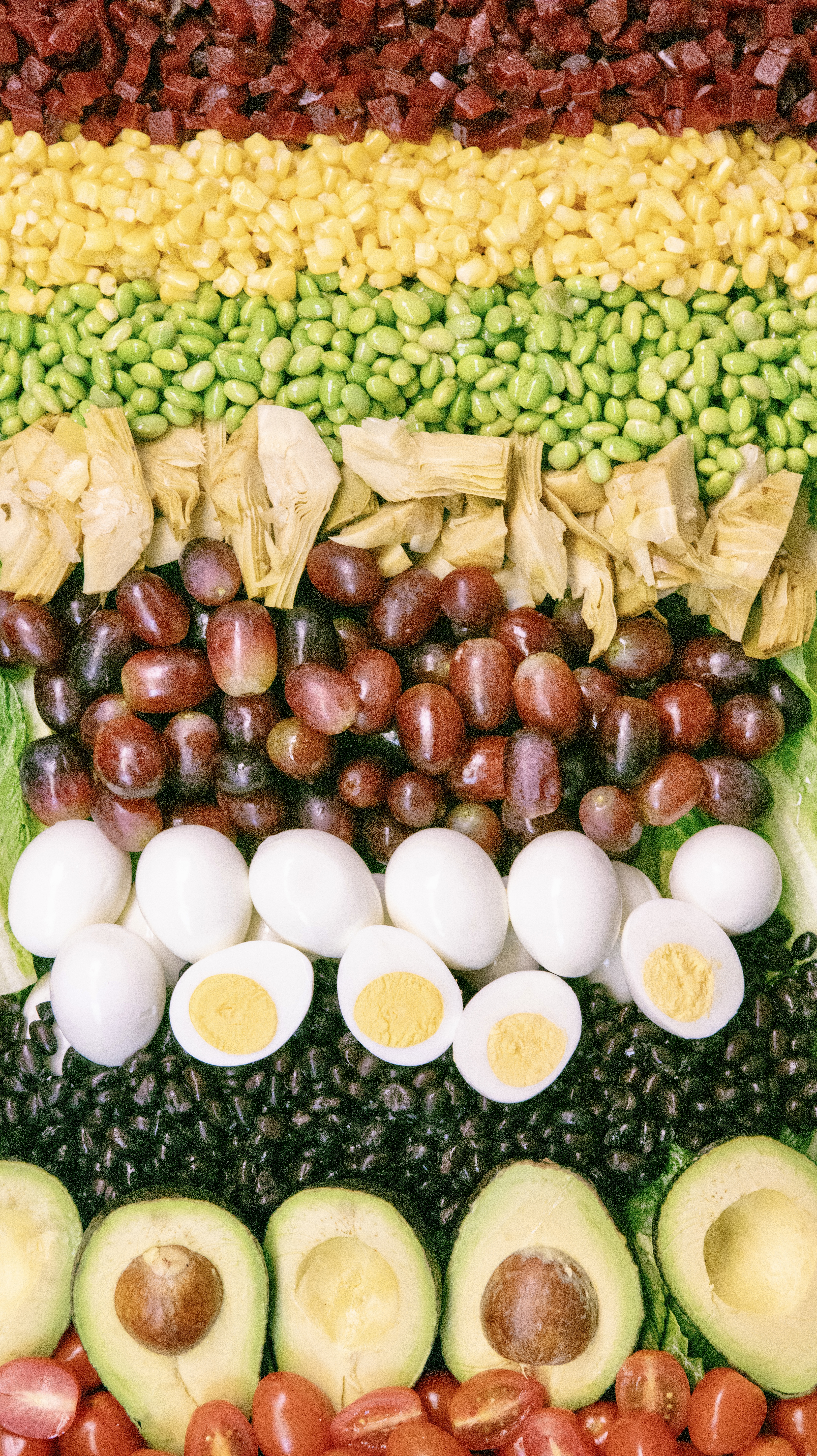 Salad bar toppings including beets, corn, edamame, artichokes, grapes and eggs