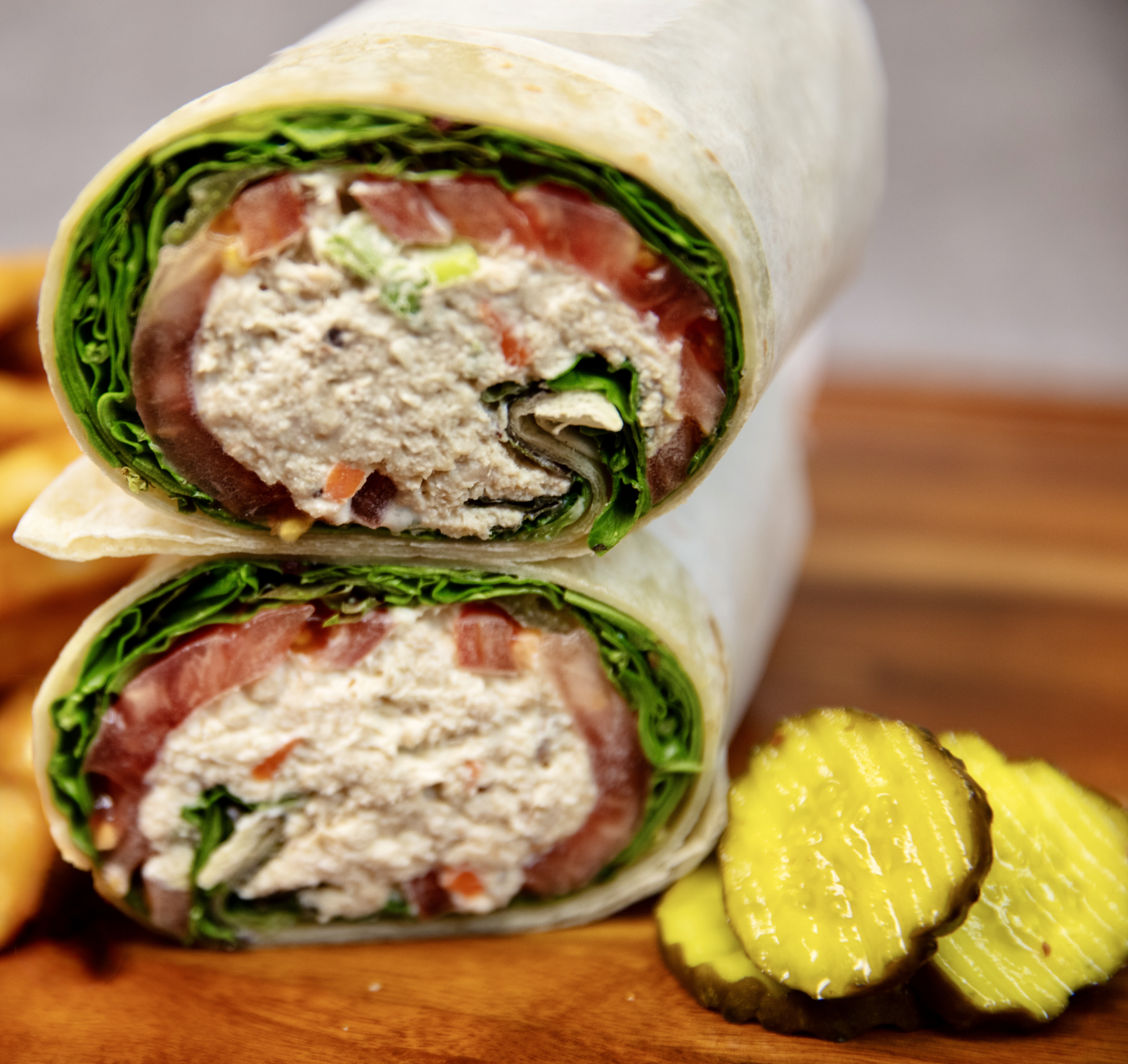 Classic tuna wrap sliced in half with pickles